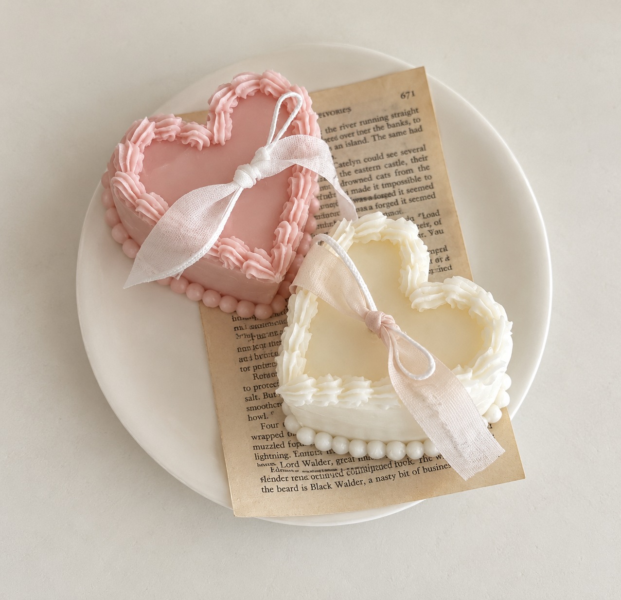 Pink and ivory heart-shaped candles with delicate piped edges